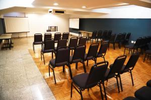 ein leeres Zimmer mit Stühlen und einem Whiteboard in der Unterkunft Hotel BH Palace in Belo Horizonte