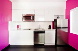 a kitchen with white cabinets and a stainless steel refrigerator at Blanc Kara Boutique Hotel in Miami Beach +41 photos