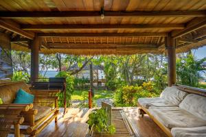 an outdoor living room with a couch and a table at Santai Hotel in Amed