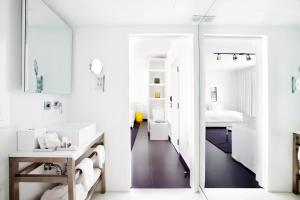 a white bathroom with a mirror and a sink at Blanc Kara Boutique Hotel in Miami Beach