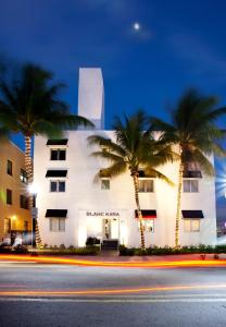 a building with palm trees in front of a street at Blanc Kara- Adults Only in Miami Beach