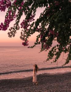 a little girl standing on the beach near the water at Santai Hotel in Amed