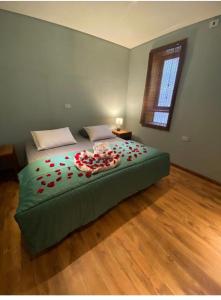 a bedroom with a bed with red roses on it at Espaço Tajj in São Roque