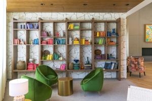 ein Zimmer mit zwei grünen Stühlen und einem Bücherregal in der Unterkunft Town and Country San Diego in San Diego