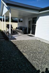 a patio of a house with a couch and a table at Ashley's Retreat Umina Beach in Umina