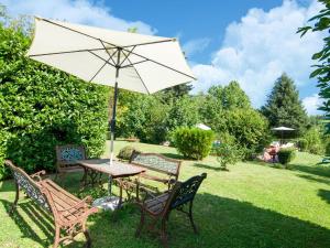 a table and chairs with an umbrella in the grass at Magnificent Holiday Home in Amandola with 2 Private Pools in Amandola