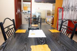 a black table with yellow napkins on top of it at Mercy-Phillips Apartments Located at Eagle Tower Building Nairobi City Centre in Nairobi