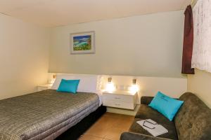 a hotel room with a bed and a couch at Matilda Motel in Bundaberg