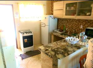 a kitchen with a white refrigerator and a stove at CASA DE PRAIA - Verão Vermelho I - Cabo Frio - Unamar in Cabo Frio