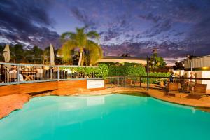 a swimming pool with blue water in a resort at Potshot Hotel Resort in Exmouth