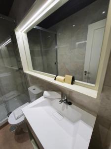 y baño con lavabo blanco y espejo. en Le Petit Palü-Ópera en Madrid