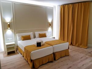 1 dormitorio con 1 cama grande y cortinas amarillas en Le Petit Palü-Ópera en Madrid