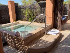 a hot tub with a metal rail in a backyard at Sierra Grande Lodge & Spa in Truth or Consequences