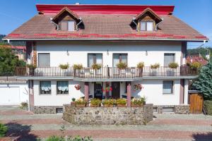 a white house with flowers on the balcony at Casa Din Noua in Braşov