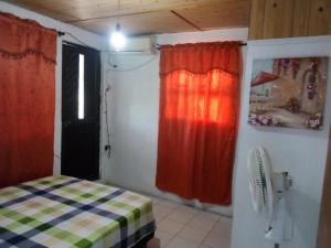 a room with a bed and a fan and a window at Marysol Lodging in San Andrés