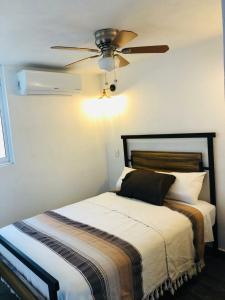 - une chambre avec un lit et un ventilateur de plafond dans l'établissement Dep Aurora by Hansa AC Wifi 5 min de playa, à Puerto Vallarta