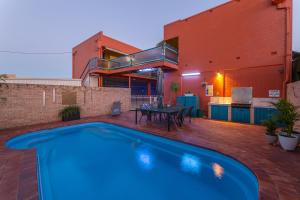 a swimming pool in front of a house at Matilda Motel in Bundaberg