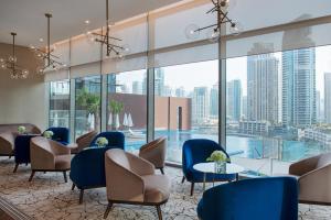 un hall avec des chaises et des tables ainsi qu'une piscine dans l'établissement Jumeirah Living Marina Gate Hotel and Apartments, à Dubaï