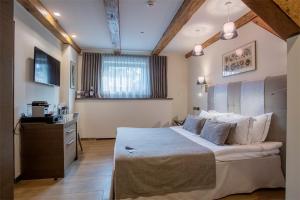 1 dormitorio con 1 cama grande y escritorio en Michaelson Boutique Hotel en Klaipėda