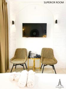 twee stoelen en een tafel in een kamer met een tv bij A In Hotel Glamour in Ho Chi Minh-stad