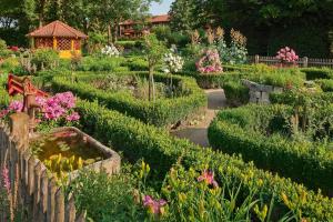 a garden with a pond and many flowers at Hotel Alter Weißbräu in Bad Birnbach