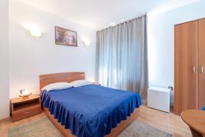 a bedroom with a blue bed and a table at Casa Din Noua in Braşov