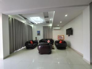 una sala d'attesa con tre sedie e un televisore di Al Basateen Hotel Rumays a Rumays
