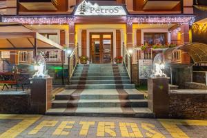 een trap die 's nachts naar een restaurant leidt bij Petros Hotel in Boekovel
