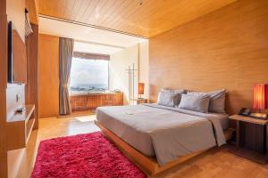 a bedroom with a large bed and a red rug at The Senses Resort & Pool Villas - SHA Plus in Patong Beach