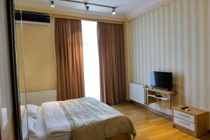 a hotel room with a bed and a television at Happy Stay Hotel in Kutaisi