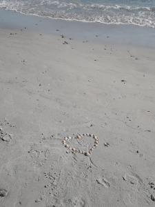 un cuore disegnato sulla sabbia sulla spiaggia di Al Sale a Cagliari