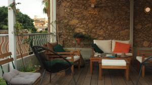 a patio with chairs and tables and a stone wall at Al Sale in Cagliari