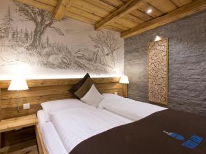 a bedroom with a white bed with a painting on the wall at Hotel Crusch Alba Zernez in Zernez
