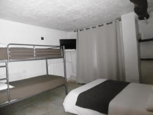 a bedroom with a bunk bed and a television at Le Relais Des Vieilles Postes in Les Avenières