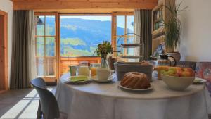 a table with food on it in a room with a window at Landhaus Hinteregg Apartment in Schladming