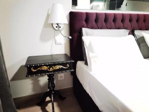 un lit avec une table et une lampe. dans l'établissement Downtown Loulé, à Loulé