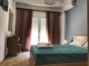 a bedroom with a green bed with a window at Midway Point Apts in Heraklio Town