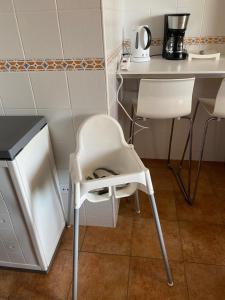 einen weißen Stuhl in einer Küche mit einem Tisch in der Unterkunft fantastic apartment Spain Algarve vacation & boat fun in Ayamonte