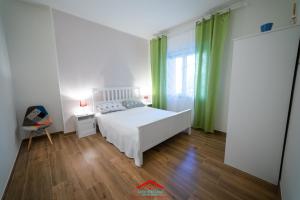 een slaapkamer met een wit bed en groene gordijnen bij Casa stellata Napoli home in the center in Napels