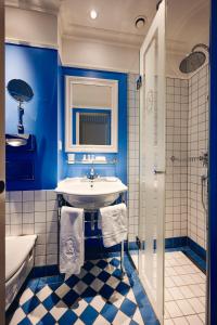 a blue bathroom with a sink and a tub at Hotel Europe in Zurich