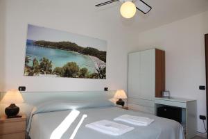 una camera da letto con un letto e due asciugamani di Hotel Villa Wanda a Porto Azzurro