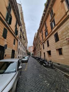 een geplaveide straat met geparkeerde auto's en gebouwen bij Hotel Martino Ai Monti in Rome