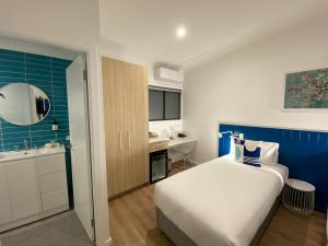 a hotel room with a bed and a bathroom at The Cubana Ballina in Ballina