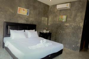 a bedroom with a white bed with a flower on it at Phuwadee Resort Khao Yai in Nong Sarai