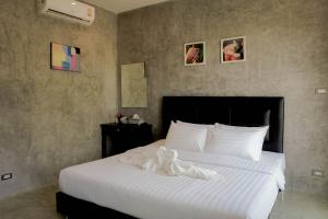 a bedroom with a large bed with a white blanket at Phuwadee Resort Khao Yai in Nong Sarai