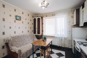 a kitchen with a table and a couch and a window at Apartment on Kharkovskaya 2 floor in Sumy +21 photos