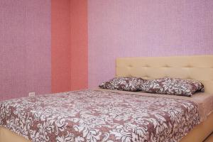 a bed in a bedroom with pink and purple walls at Apartment on Kharkovskaya 2 floor in Sumy