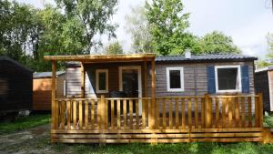 eine Hütte mit einer Veranda und einer Terrasse in der Unterkunft Mobil-Home Cosy - Matelas qualité hôtel in Passy