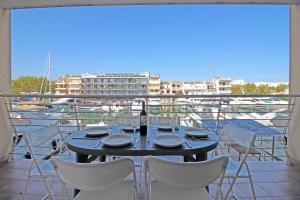 - une table avec des chaises et une bouteille de vin sur le balcon dans l'établissement Apart-rent Apartment Port Salins 0163, à Empuriabrava