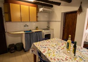 - une cuisine avec une table et 2 bouteilles de vin dans l'établissement Cal Conxé, à El Vilosell